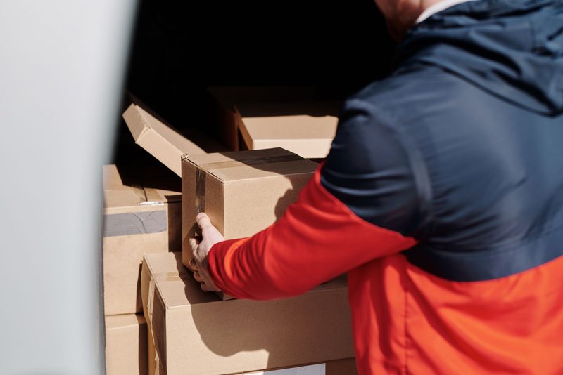 Ware wird am Packtisch in neue Kartons umgepackt